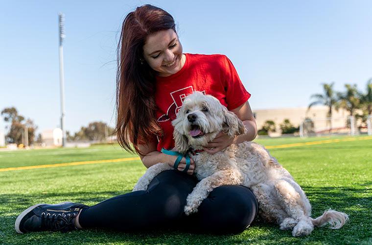 一名学生与一只治疗犬互动