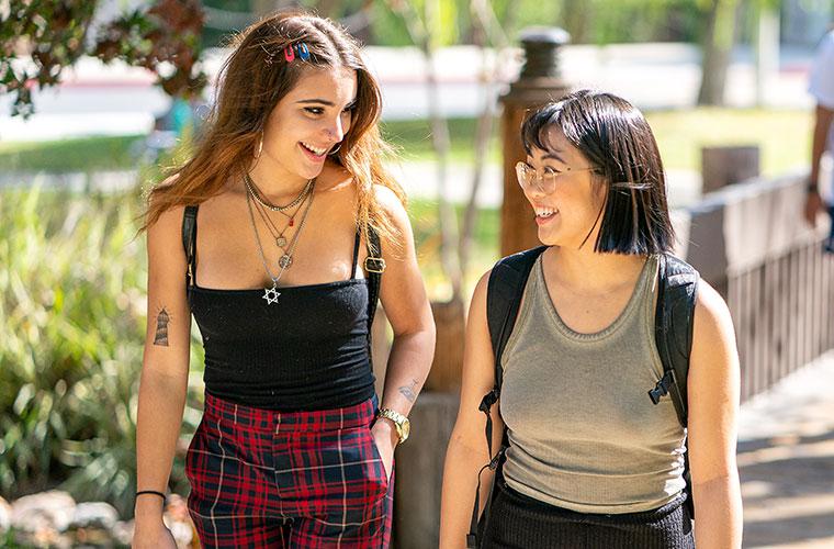 Two students walking near Scripps Cottage